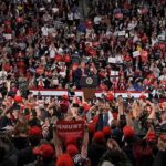 Trump Headlines Midterm Convention Speaker at podium addressing large crowd in arena