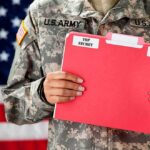 Soldier holding a red folder labeled top secret