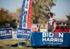 Volunteer at outdoor campaign table with Biden Harris signs
