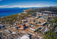 Aerial view of lakeside city with casinos, hotels, and pine forests