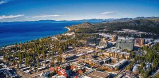 Aerial view of lakeside city with casinos, hotels, and pine forests