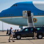 Marine Freed — Russia’s Conviction Still Sticks Security detail near blue and white aircraft with staircase and SUV