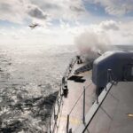 naval warship firing deck gun at sea