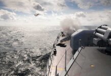 naval warship firing deck gun at sea