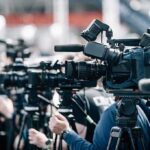 FDA Flip-Flop Sparks Lettuce Firestorm Broadcast cameras on tripods at a press event