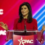 Nikki Haley speaks at a podium with a colorful backdrop