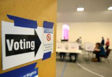 Seven Arrests, Hundreds Misflagged For Illegal Voting Voting sign on door leading to polling place