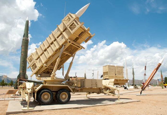 Patriot missile defense system on display outdoors with various missiles in the background