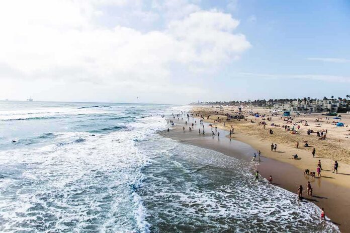 shutterstock_697274677 Crowded sandy beach with people by the shoreline