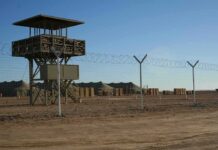 U.S. Base Plan Advances in Poland Guard tower beside barbed-wire fence in desert camp