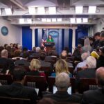 Trump Picks Wall Street Lawyer as Spy Chief Press secretary at podium addressing reporters in briefing room