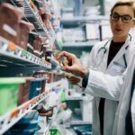 Newborn Death Sparks Measles Classification Dispute Pharmacists selecting medication from pharmacy shelves
