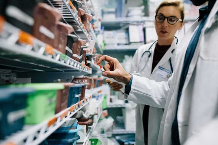 Pharmacists selecting medication from pharmacy shelves