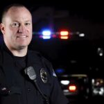 Midnight Raid: Georgia Police Officer Shoots Family’s Pet Donkey Police officer standing at night with patrol car lights in background