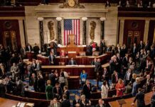 Leonard Lance and Claude Guéant among lawmakers on a legislative chamber floor