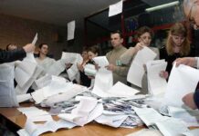 People counting ballots at a table