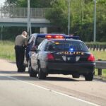 20-Year-Old Haitian Student Dies After Highway Incident, Police officer conducting a traffic stop on a highway