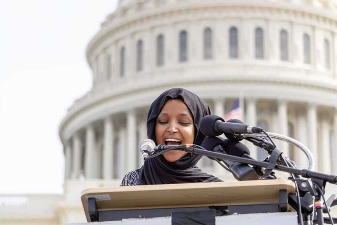 shutterstock_1347895214 Woman in hijab speaking at podium with microphones