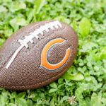 Trump Pays Tribute to NFL Legend Football on grass with orange C logo