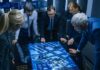 Group of professionals analyzing a digital map on a touch table