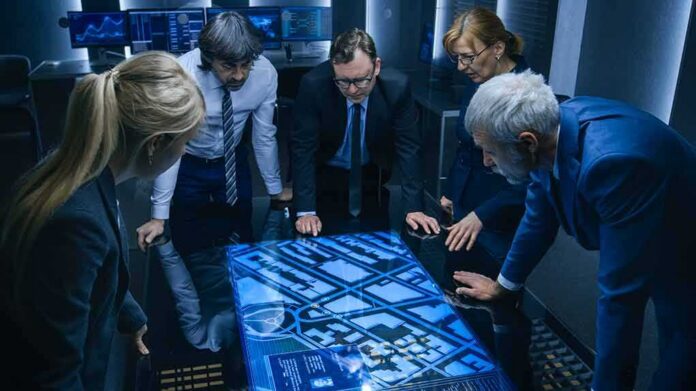 Group of professionals analyzing a digital map on a touch table