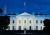 White House illuminated at dusk with flagpole and columns