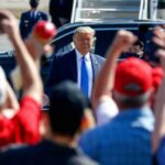 Trump Blends Rally Politics With Policy Claims Man in suit greeted by crowd with raised hands