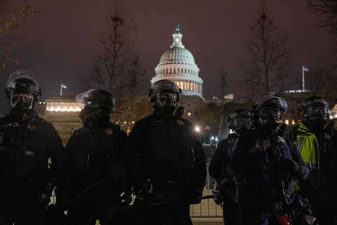 shutterstock_1913478499 Riot police in protective gear stand before a domed capitol building at night