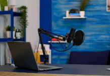 Execution Broadcast Sparks Debate Podcast microphone and laptop on desk in modern studio