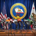 California’s New Laws Take Effect Next Year Press microphones at a podium before California governor seal