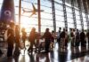 Haitians Face Danger After Deportation Passengers queue inside an airport terminal at sunset