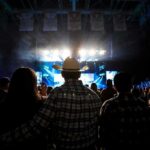 “Free Palestine” Message Appears on Gillette Stage Cowboy-hatted man watches a concert in a packed arena