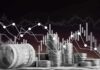 Stacks of coins and rolled dollar bills with falling financial charts