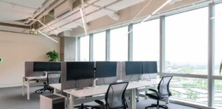 Modern open-plan office with workstations by large windows