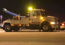 Aftershock Parking Dispute Sparks Police Report Tow truck with flashing lights parked at night
