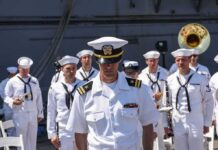 Military Boards Back Transgender Troops naval officer in white uniform stands before a military band