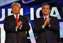 two men in suits clapping on a brightly lit stage