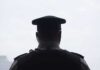 security officer seen from behind wearing cap and earpiece