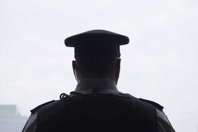 security officer seen from behind wearing cap and earpiece